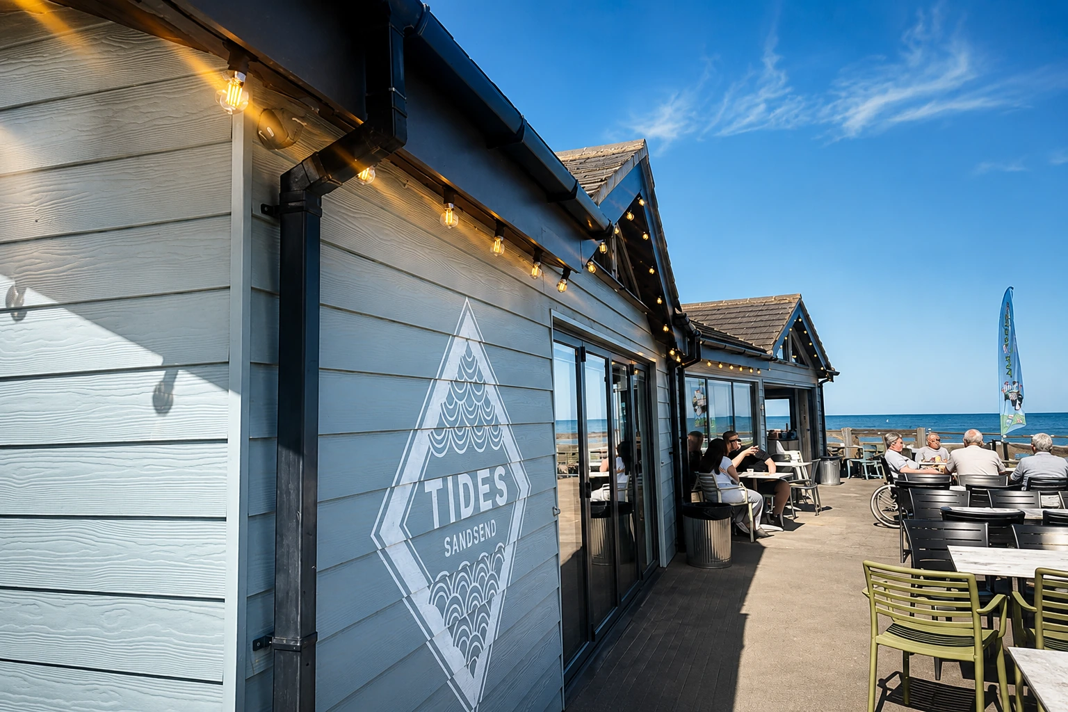 The Tides Sandsend beach-side café exterior with its painted Tides sign and outdoor seating