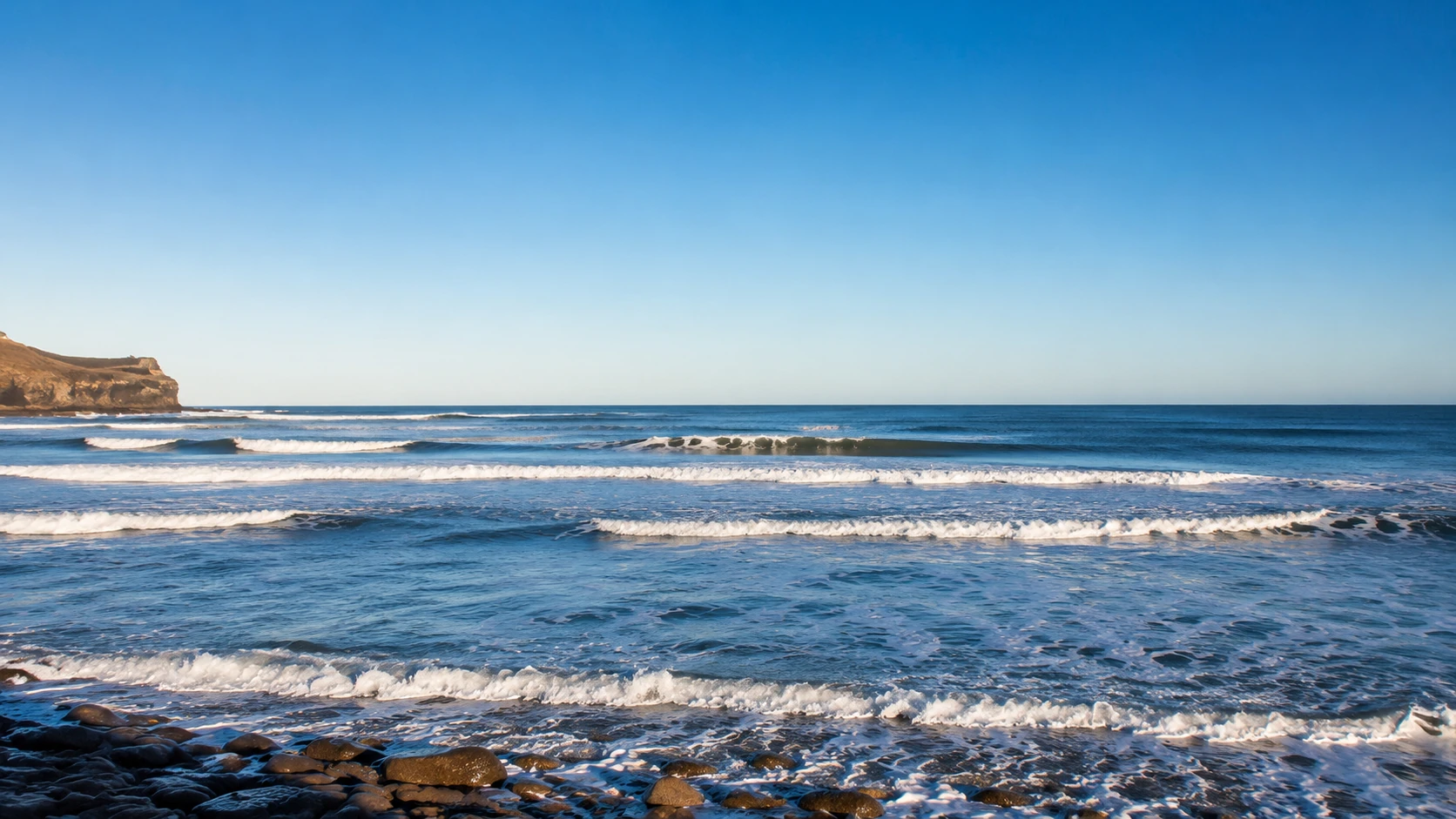 Waves rolling towards the rocky shoreline at Sandsend